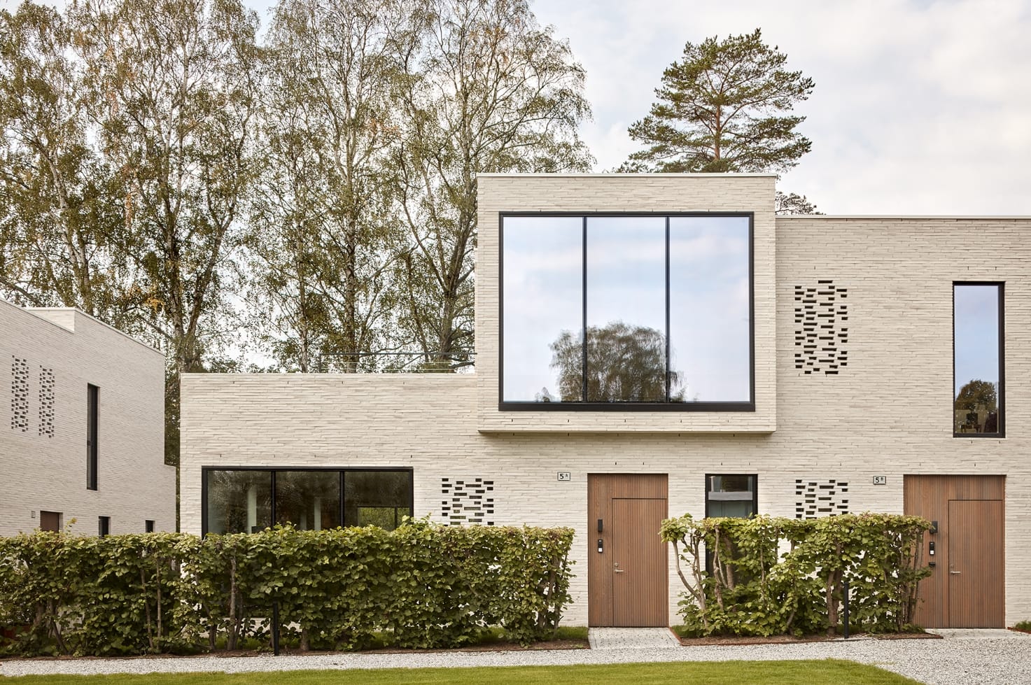 boligkompleks i hvide mursten tegnet af reiulf ramstadt arkitekter.